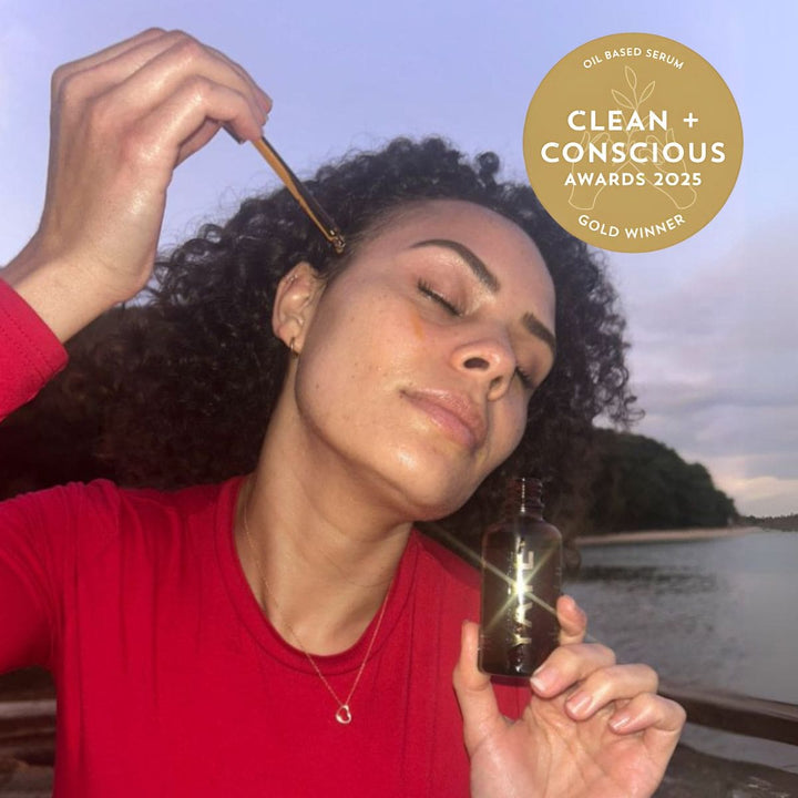 Woman applying Yaye Red Ochre Face & Body Oil with gold Clean + Conscious Award badge – Aboriginal-owned Australian skincare with native botanicals