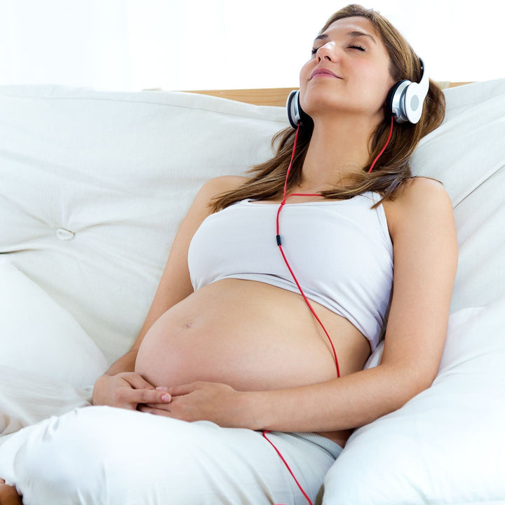 Pregnant woman relaxing with headphones – Yaye Aboriginal soundscape audio for stress relief, prenatal calm, and mindful rest